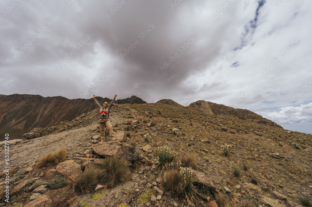 Woman explorer takes photos of the great volcanic landscape of Nevado de Toluca, Mexico, while enjoying a beautiful cloudy day from one of the crater summits.