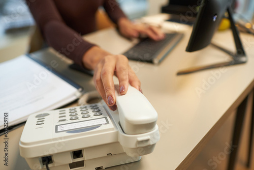 Foto Close up of young woman answering phone calls at desk in office, copy space