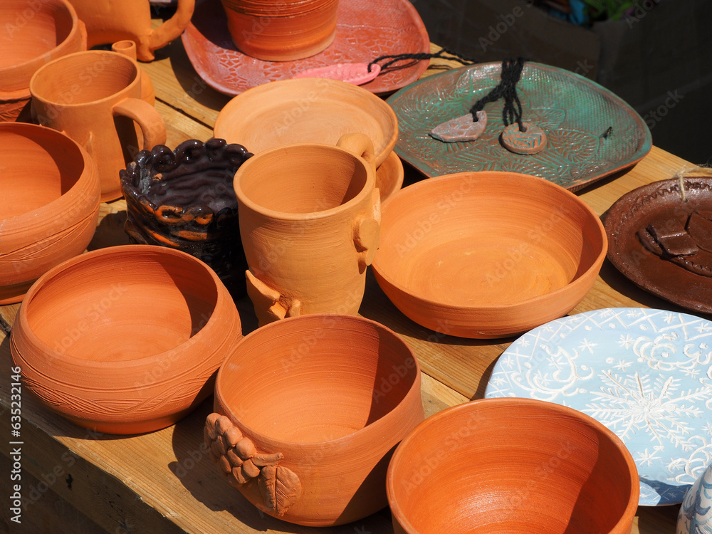 Ceramic tableware with natural patterns painted, close-up. Objects of ethnic crafts, small business, handmade.