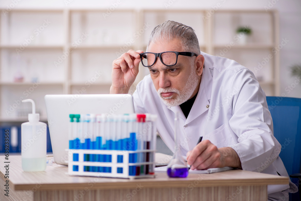 Old male chemist working at the lab Old male chemist working at the lab