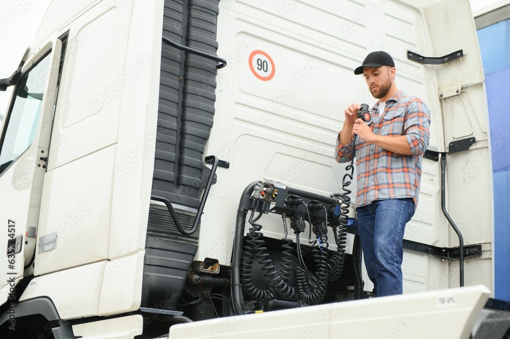 View of a driver connecting the power cables to trailer of a commercial truck. View of a driver connecting the power cables to trailer of a commercial truck.