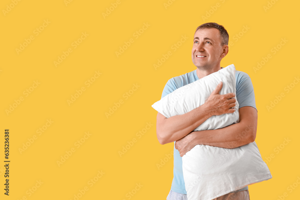 Mature man with soft pillow on yellow background Mature man with soft pillow on yellow background