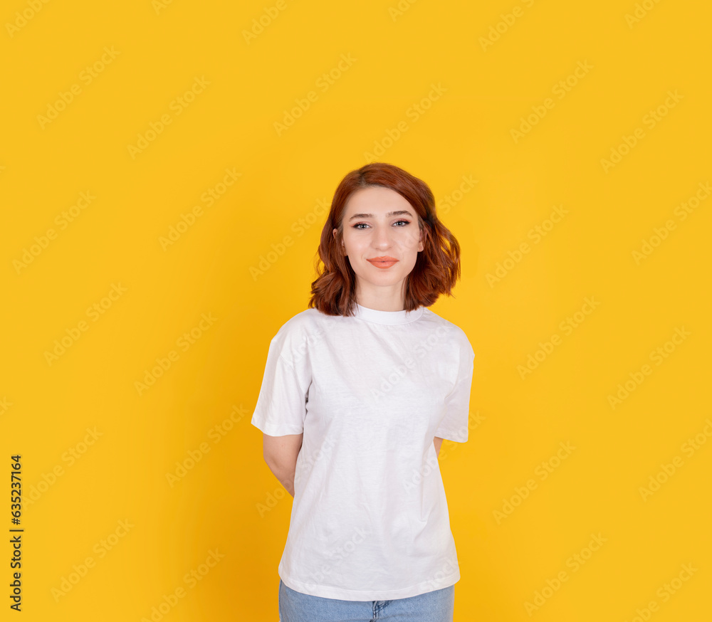 Pretty young redhead girl, portrait of young caucasian European pretty young redhead girl. Wear casual white t-shirt, looks with joy smiling. Light blue eyes. Isolated yellow background, copy space. Pretty young redhead girl, portrait of young caucasian European pretty young redhead girl. Wear casual white t-shirt, looks with joy smiling. Light blue eyes. Isolated yellow background, copy space.