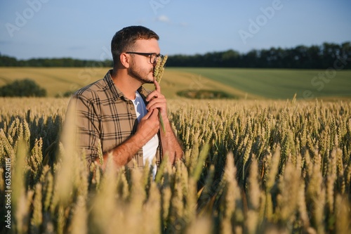 Farmer examining crops crouching in wheat farm