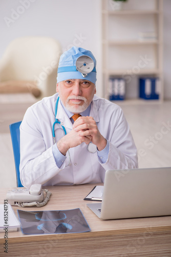 Old male doctor otologist working in the clinic