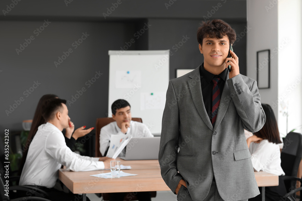 Male business consultant talking by mobile phone in office Male business consultant talking by mobile phone in office