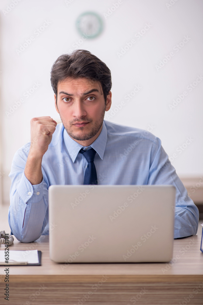 Young male employee working in the office Young male employee working in the office