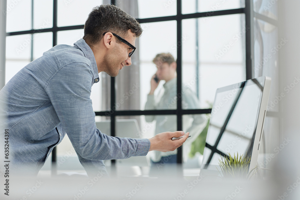 the manager writes in a notebook leaning over the table in the office