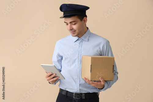 Young postman with tablet c...