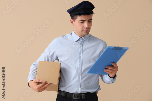 Young postman with parcel a...