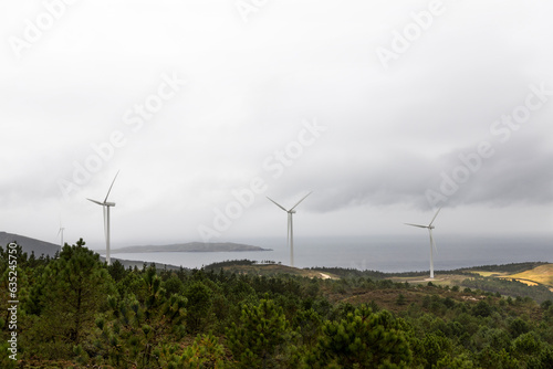 Four wind turbines with fog and clouds