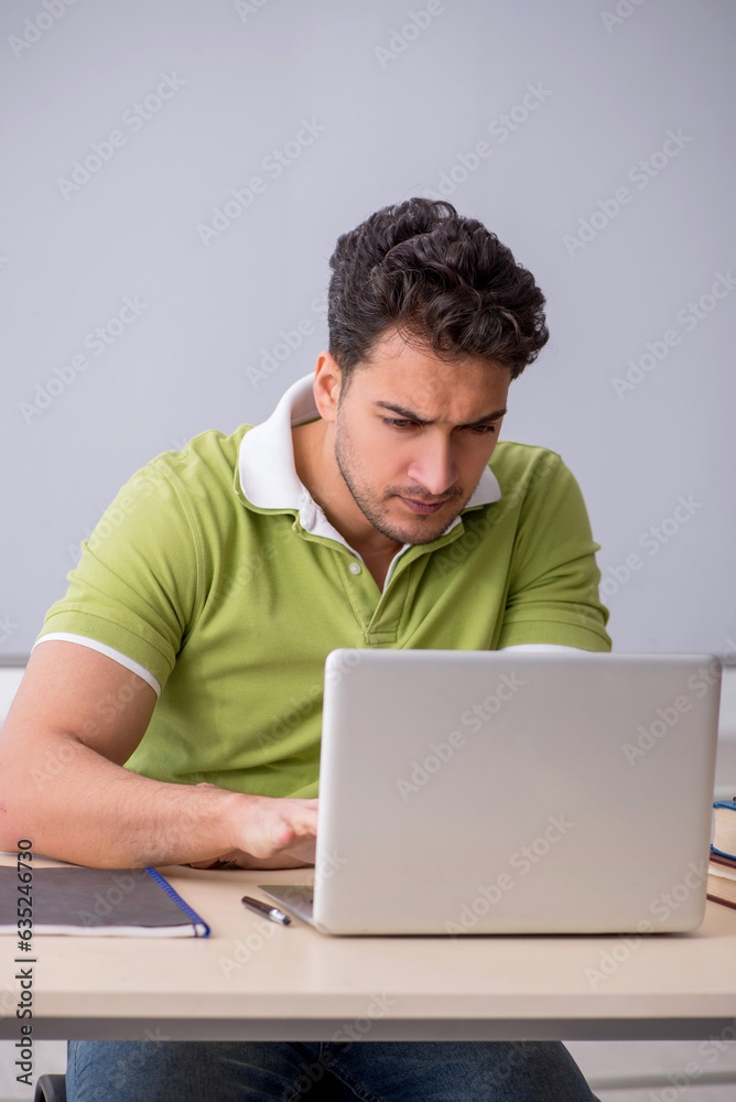 Young male student in telestudying concept Young male student in telestudying concept