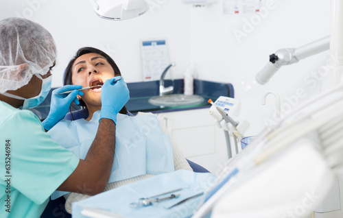 Portrait of female patient during dental checkup in modern dentist office. Health care and oral hygiene concept