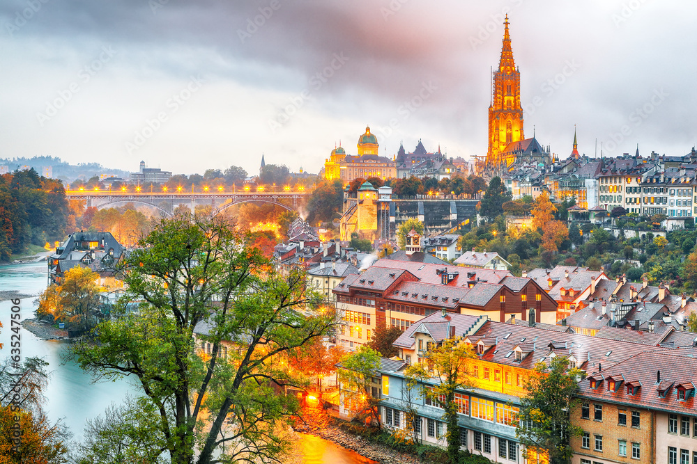 Obraz premium Amazing autumn view of Bern city on Aare river during evening with Cathedral of Bern on background.