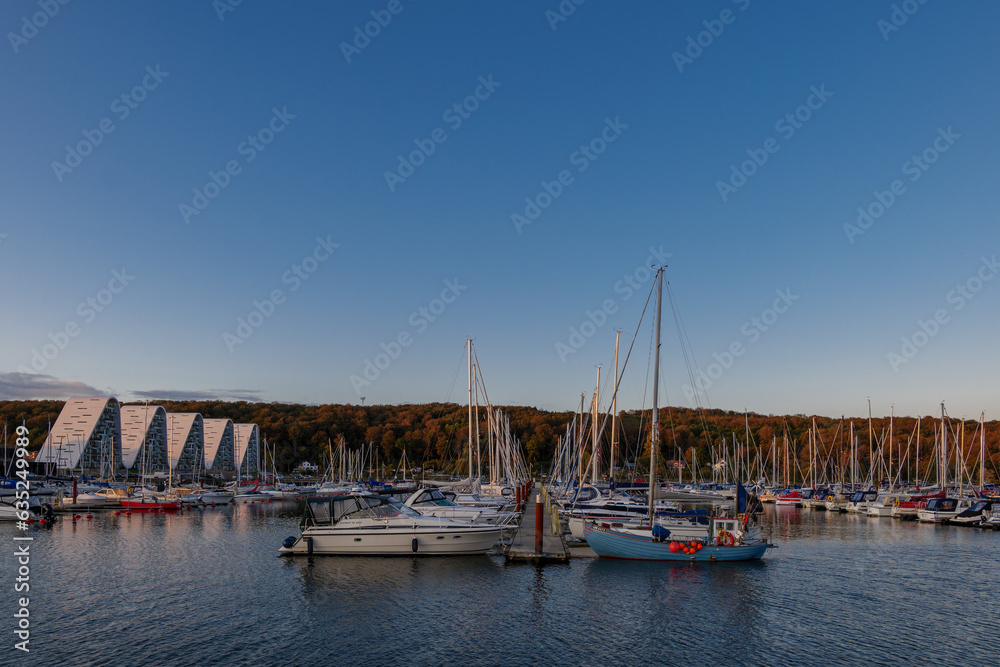Fototapeta premium Outdoor exterior view at Vejle Havn Mole, row of yachts pier and the wave apartment during twilight sky in Vejle, Denmark.