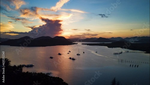 Aerial Forward Shot Of Tranquil Mountains And Sea Against Cloudy Sky At Sunset - Mapun, Philippines photo