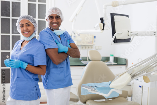 Portrait of positive dentist with assistant at workplace in clinic