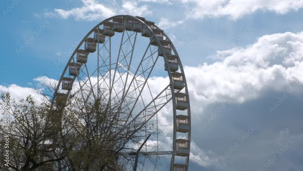 Working observation wheel against sky. A view of working observation wheel against sunny blue sky in the park. Working observation wheel against sky. A view of working observation wheel against sunny blue sky in the park.