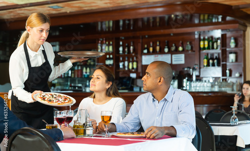 Helpful waitress brought delicious pizza to restaurant guests