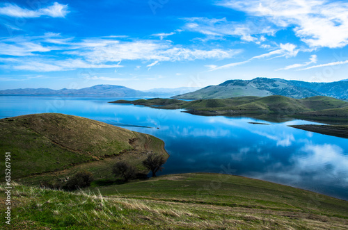 Fototapeta Naklejka Na Ścianę i Meble -  Nature's masterpiece unfolds as California's majestic mountains cradle a tranquil water reservoir, a harmonious symphony of land and liquid