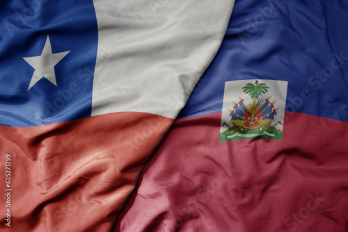 Photography big waving realistic national colorful flag of chile and national flag of haiti