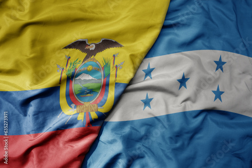 big waving realistic national colorful flag of ecuador and national flag of honduras .