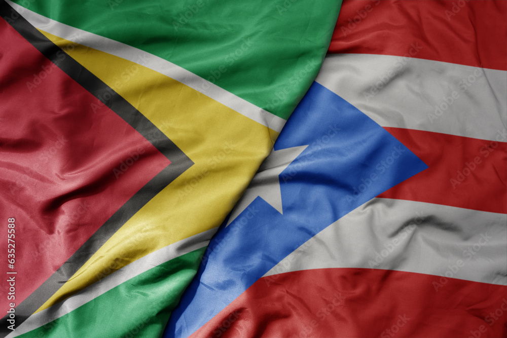 big waving realistic national colorful flag of guyana and national flag of puerto rico .