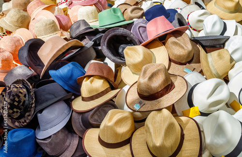 Men's and women's hats stacked at a Colombian street stall
