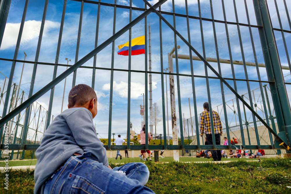 Teenager watches a soccer game on a field in the El Mirador neighborhood in the suburbs of Bogota Teenager watches a soccer game on a field in the El Mirador neighborhood in the suburbs of Bogota