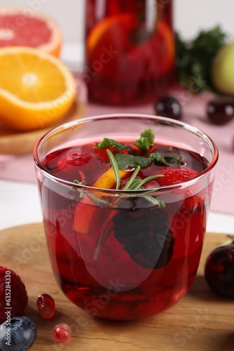 Glass of delicious refreshing sangria on wooden board, closeup