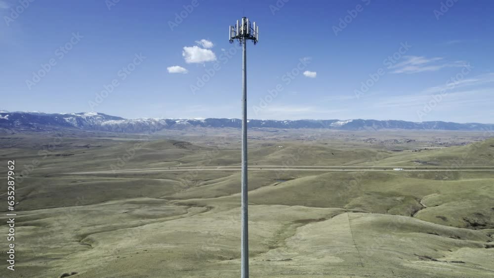 Wide establishing aerial shot of cell tower. Tall metal pole on hill in northwest US with 4G/5G antenna array at top. HDR 4K ProRes drone footage. Wide establishing aerial shot of cell tower. Tall metal pole on hill in northwest US with 4G/5G antenna array at top. HDR 4K ProRes drone footage.