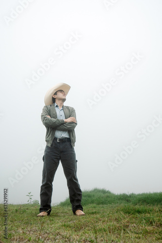 Cowboy Delight - Man in Mexican Hat and Boots amid Foggy Landscape