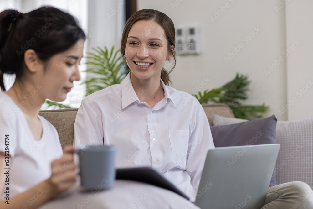 Two Happy asian Ladies Using Laptop Computer Working And Learning Online Together Or Making Video Call Sitting At on sofa in home . E-Learning. Females Entrepreneurship Career Concept. Two Happy asian Ladies Using Laptop Computer Working And Learning Online Together Or Making Video Call Sitting At on sofa in home . E-Learning. Females Entrepreneurship Career Concept.