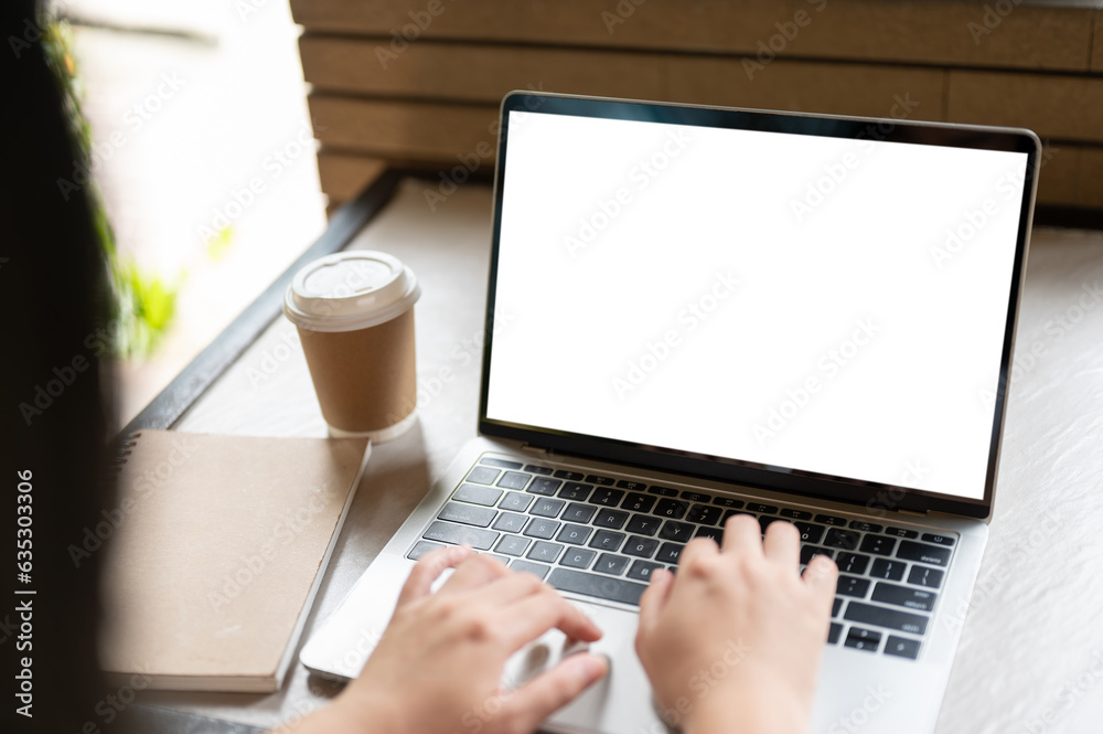 Close-up image of a female freelancer using her laptop computer at a coffee shop. Close-up image of a female freelancer using her laptop computer at a coffee shop.