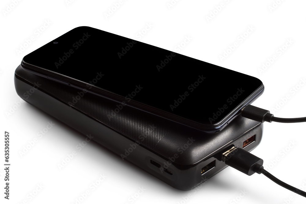 The smartphone is charged from a power bank. Charging modern devices. The smartphone is charged from a power bank. Charging modern devices.