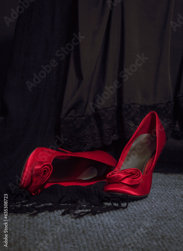 Red Shoes Lying in front of black lingerie draped with shawl fringe in Vertical Frame