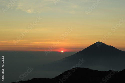 Photo illustration of a cloudy golden sunrise view from the top of Papandayan mountain
