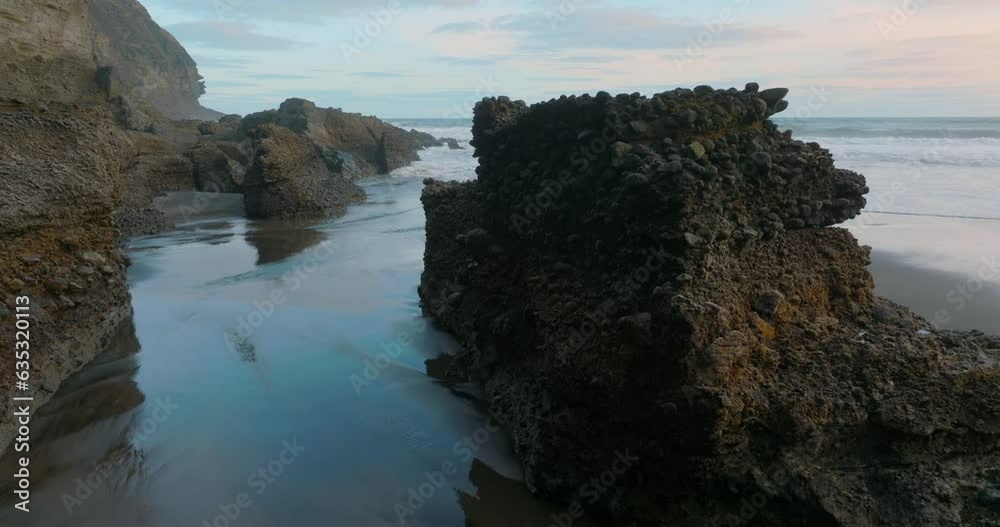 Aerial: Calm rocky coastline at sunset. Auckland, New Zealand Aerial: Calm rocky coastline at sunset. Auckland, New Zealand