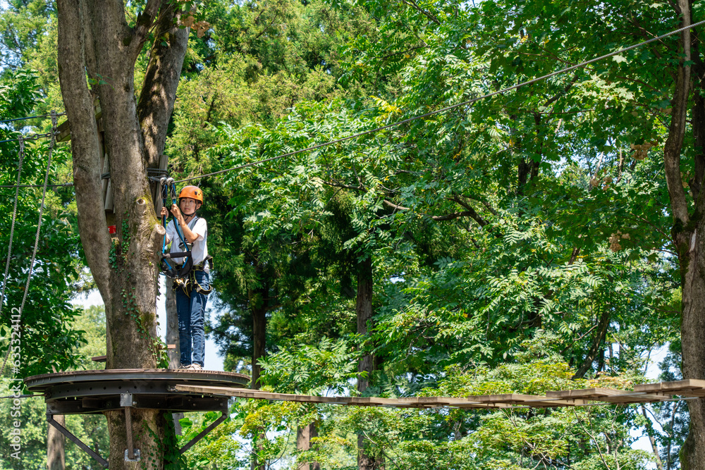 Fototapeta premium 夏休みにアスレチックで遊ぶアジア人の小学生