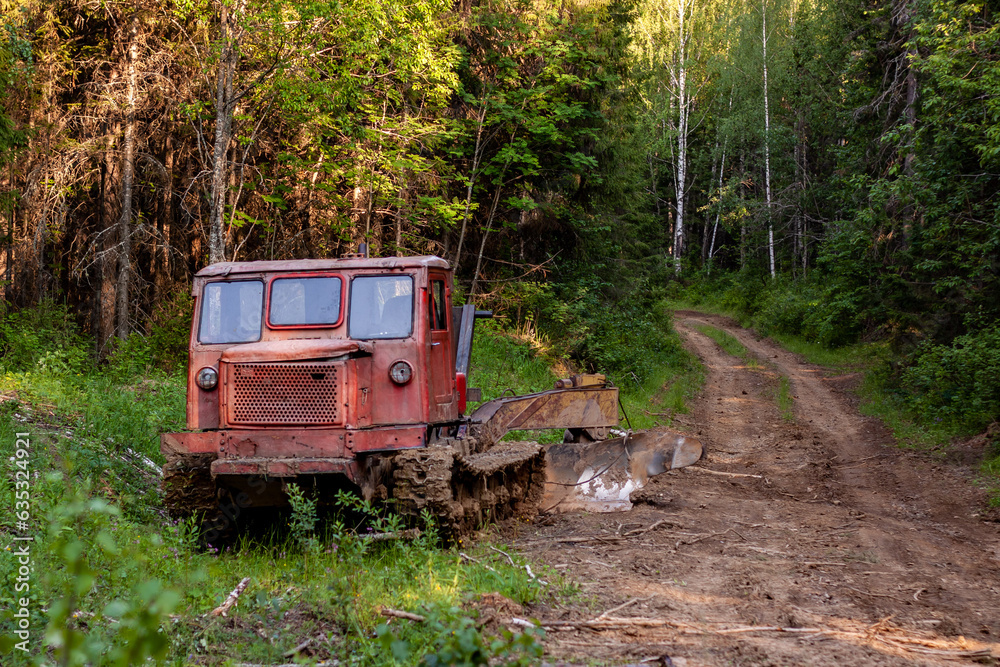Fototapeta premium A skidder on a dirt road in the taiga region of the Urals. Near the village of Sulyom, July 2023.