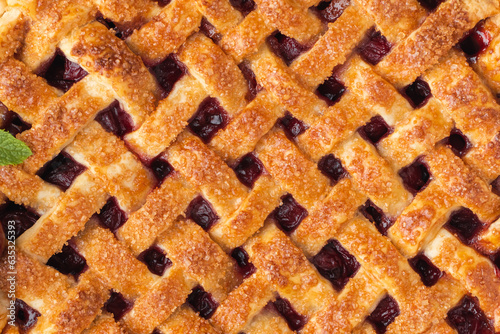 Delicious homemade cherry pie with Flaky Crust as a textured background. American traditional pastry. Flat lay. Fresh summer berry tart dessert sprinkled with sugar