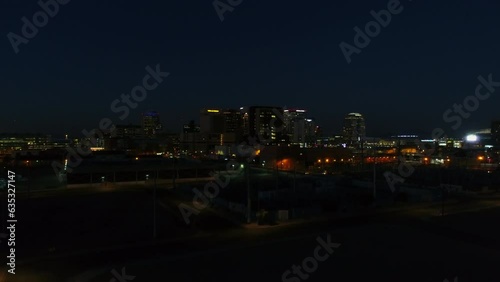 Aerial Upward Shot Of Illuminated Buildings In City, Drone Flying Over Cityscape At Night - Phoenix, Arizona photo