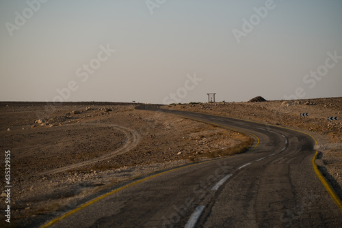 In the Negev Desert  a two-line highway curves its way through the wilderness and disappears over the top of a hill. The sky is hazy  after a windy storm swept across southern Israel.