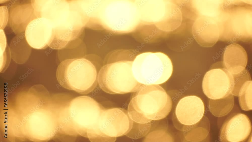 Blurred golden sea at sunset with shifting focus and bokeh effect. Sun reflects and sparkles on waves, illuminating golden sea. Holiday recreation concept. Abstract nautical summer ocean sunset nature