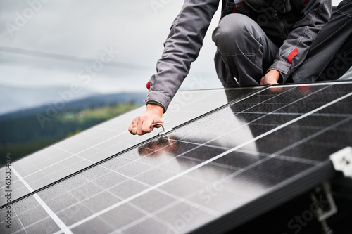 Bild auf Leinwand Man engineer mounting photovoltaic solar panels on roof of house