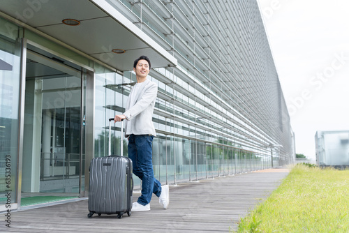 キャリーケースを持った男性（旅行・空港）