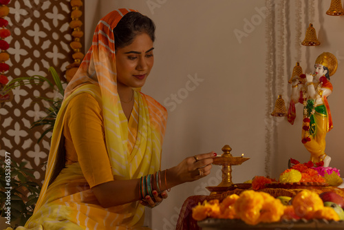 Woman worshipping Lord Krishna on the occasion of Janmashtami photo
