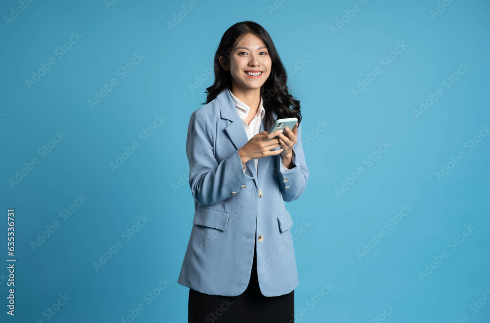 image of young businesswoman using phone on blue background image of young businesswoman using phone on blue background