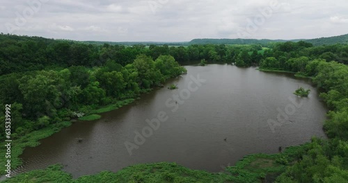 Murky Water Of River Surrounded By Trees On Overcast Day In Mousetail Landing State Park In Daytime In Linden, Tennessee, USA. - aerial photo