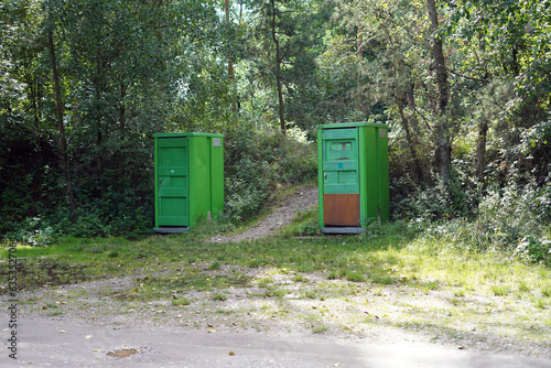Outdoor portable toilets. They are plastic and green in color.